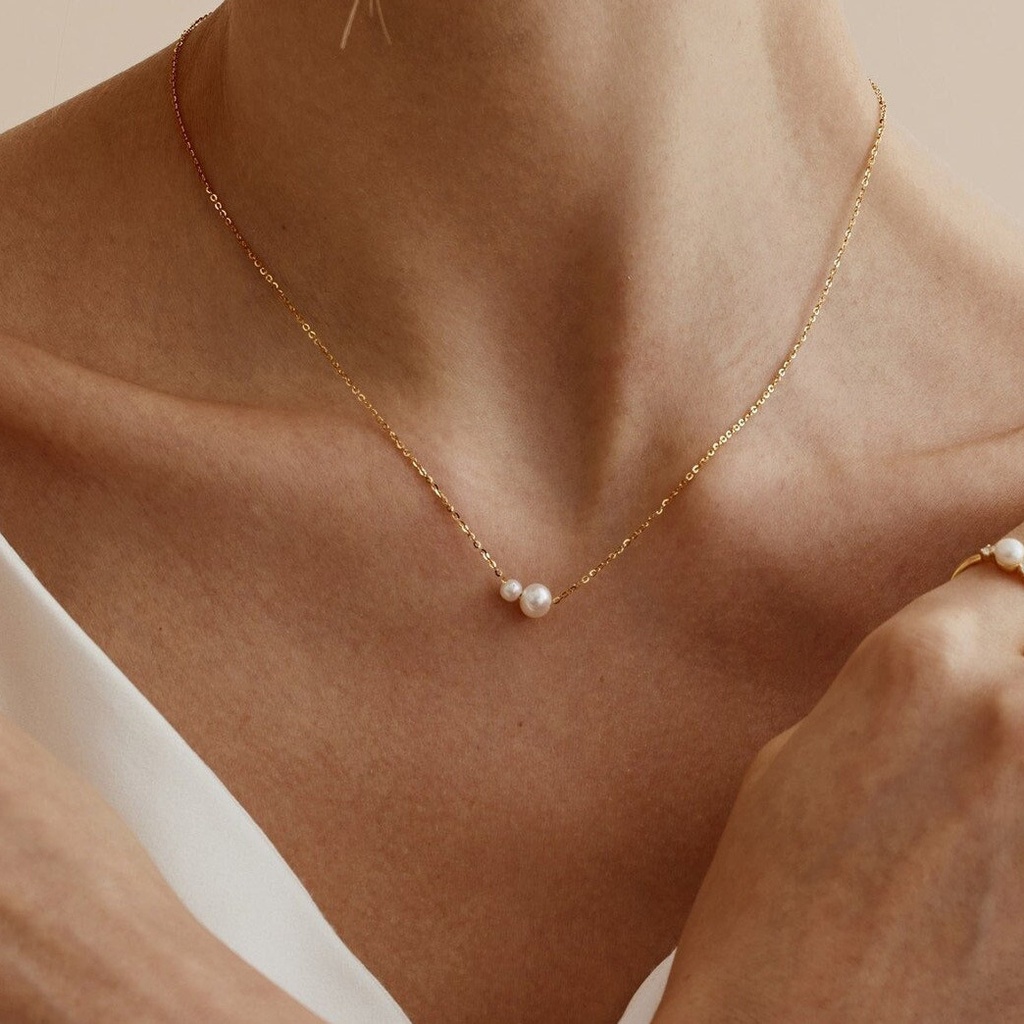 An elegant necklace featuring two pearls, perfect for adding a vintage and artistic touch to your look